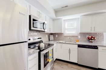 A kitchen with white appliances and cabinets.